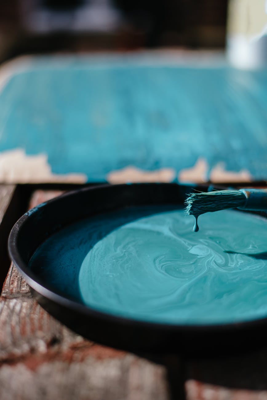 colorful paint in bowl with paintbrush