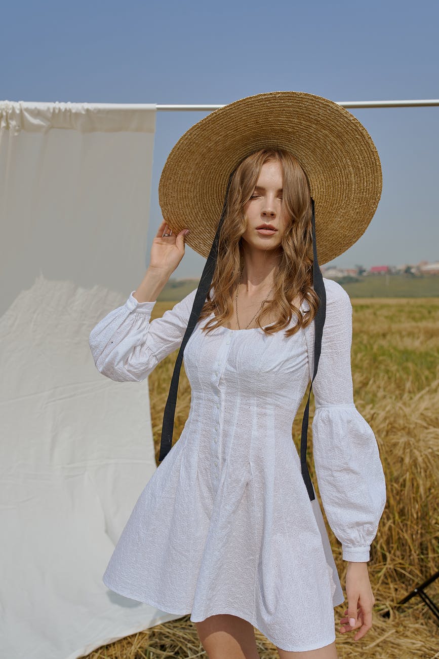 attractive woman in white summer dress standing on field